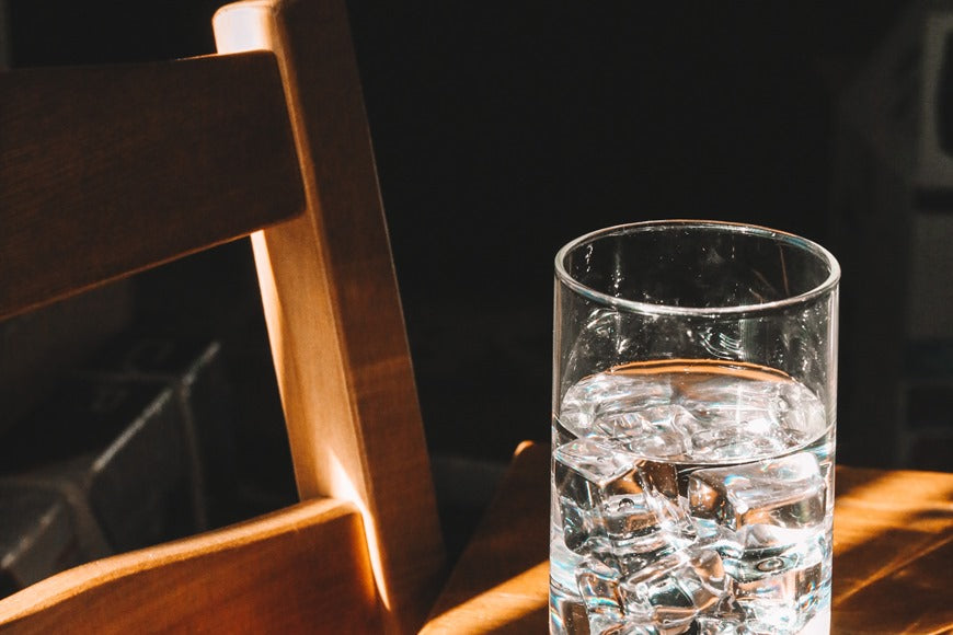 Glass of icy water on a wooden table