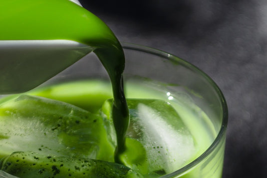 Green juice being poured in a glass