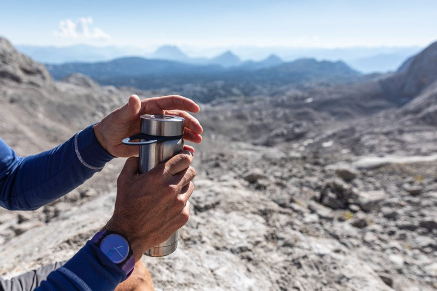 Man holding a water bottle on a hike