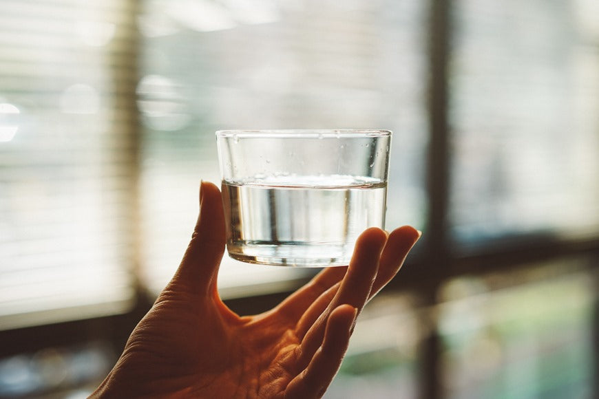 A woman holding a glass of water