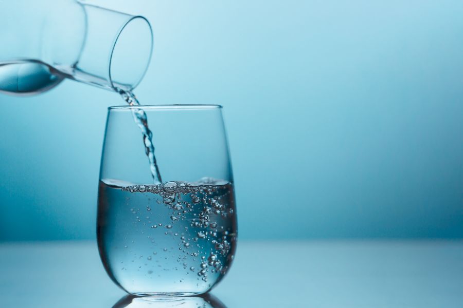 A glass of water being poured into a glass