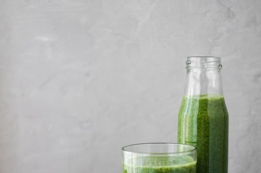 Wheatgrass juice in a bottle and a glass