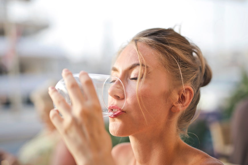 Woman drinking alkaline water from a glass